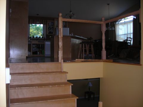 1984 Ford Bronco - Interior view of a home showing a staircase, kitchen area, and a partially constructed railing.