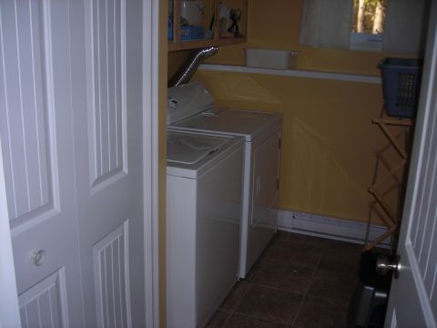 1984 Ford Bronco - A laundry room scene a washing machine and dryer, with yellow walls and a window.