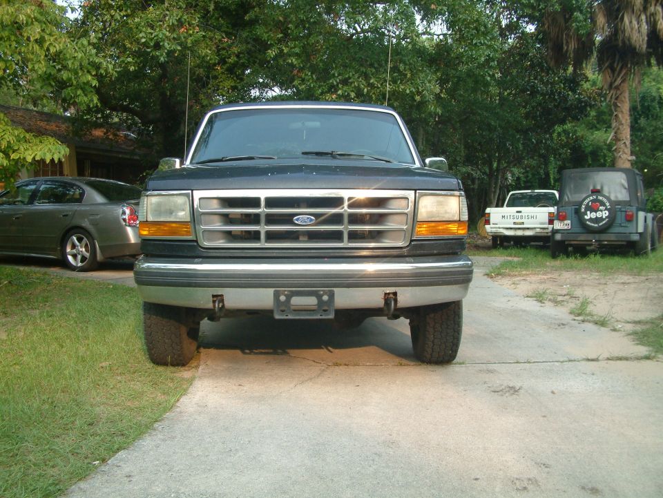 Front view of a dark green Ford pickup truck parked on a driveway