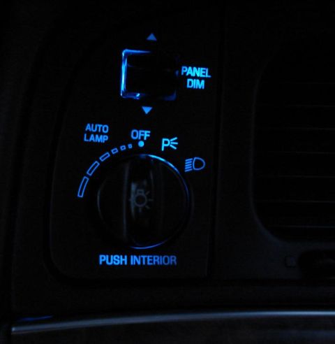 1999 Ford Crown Victoria - Night shot of a dash-mounted headlight switch converted to blue LED backlighting, with the rotary knob and the "AUTO LAMP", "OFF", "PUSH IN…