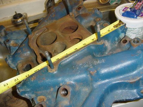 1979 Ford F-150 - A blue engine intake manifold is shown with a measuring tape and a visible part number.