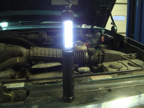1996 Ford Bronco - Working on the engine of a 1996 Ford Bronco with a portable work light.