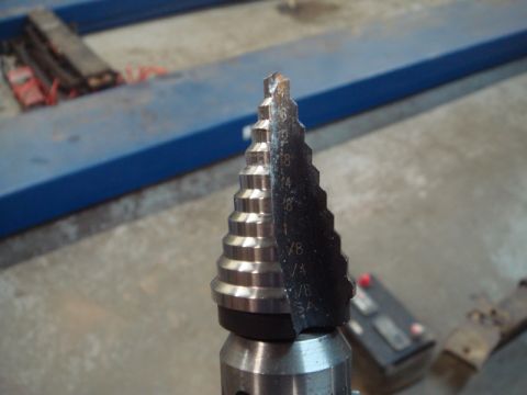 1996 Ford Bronco - A step drill bit is shown with various fractional inch size markings etched onto its side.