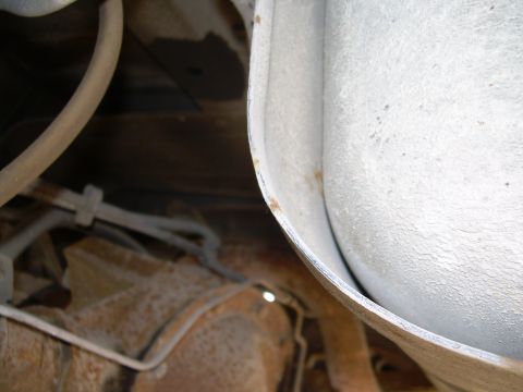 1991 Ford Bronco - Close-up view of the undercarriage, revealing the exhaust system and frame of a vehicle.
