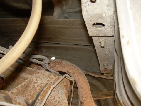 1991 Ford Bronco - Close-up view of the underbody chassis and exhaust system, showing signs of rust and wear. www.supermotors.net watermark is visible.