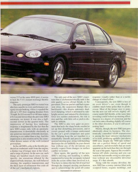 1993 Ford Taurus - A 1993 Ford Taurus SHO is shown driving on a road, with a focus on its exterior.
