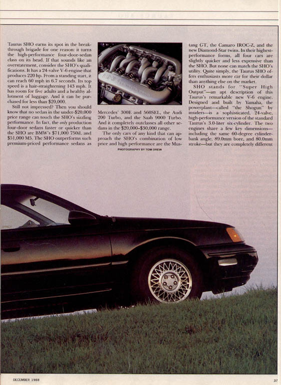 Black 1993 Ford Taurus sedan, front 3/4 view, parked on grassy incline