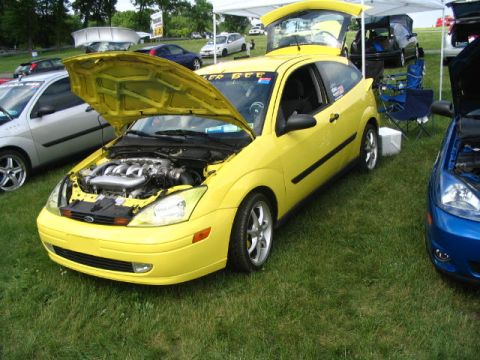 1993 Ford Taurus - A yellow Ford Focus is displayed with its hood open, revealing the engine compartment.