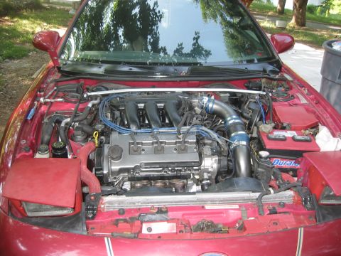 1995 Ford Probe - Engine bay of a 1995 Ford Probe, showing the V6 engine with aftermarket modifications.