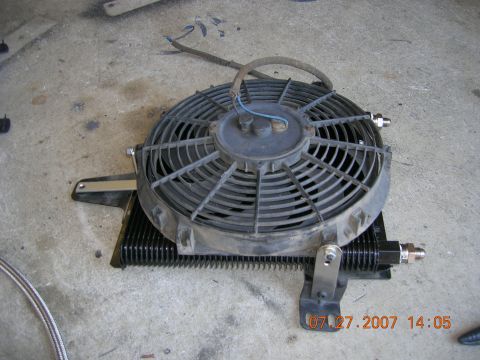 1996 Ford Bronco - An electric cooling fan is attached to an oil cooler assembly, resting on a concrete surface.