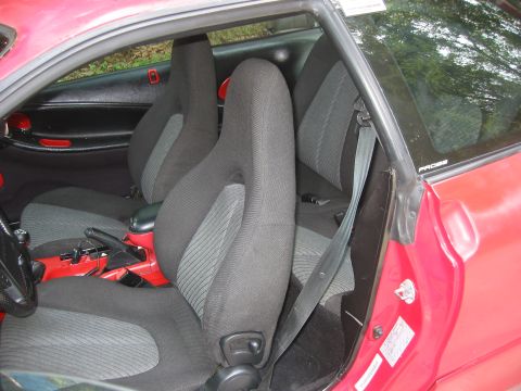 1995 Ford Probe - Interior view of a red car's front seats and door panel.
