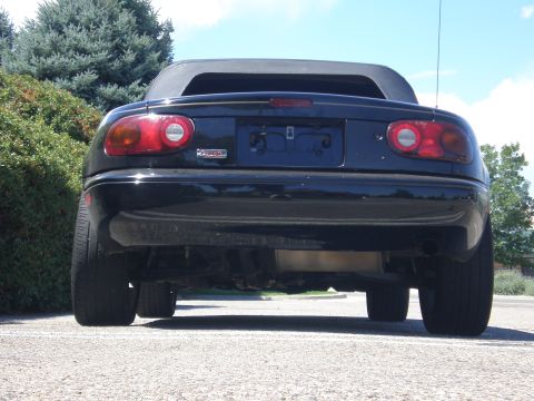 1996 Mazda Miata - Rear view of a black 1996 Mazda Miata convertible parked outdoors.