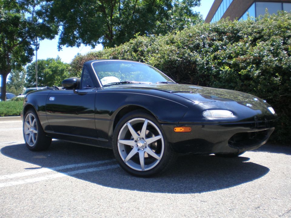 Black 1996 Mazda Miata convertible sports car, 3q front view