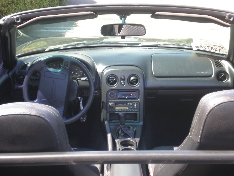 Interior view of a convertible sports car with black leather seats and a dark dashboard