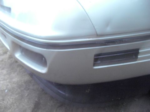 1989 Ford Probe - Front bumper corner detail of a 1989 Ford Probe, showing a dent on the hood above.