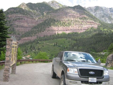 1986 Ford Bronco - A gray Ford F-150 pickup truck is parked on a road with a scenic mountain backdrop.