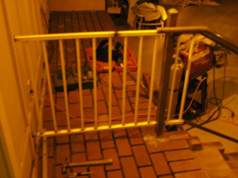 1999 Ford F-800 - A welding setup is visible behind a railing, with a brick floor and wall in the background.