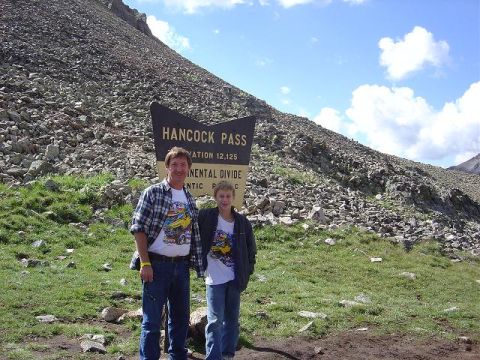 1986 Ford Bronco II - A father and son pose for a photo at the summit of Hancock Pass, a scenic mountain location.