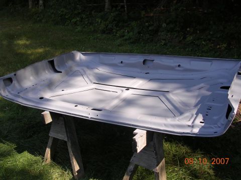 1978 Ford Bronco - Underside of a car hood on sawhorses, ready for restoration or painting.