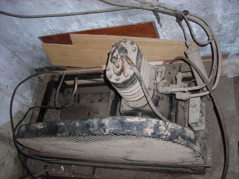 1995 Ford Bronco - Close-up of an old air compressor's cylinder and front fan shroud.