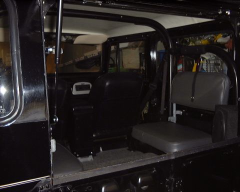 1974 Toyota Land Cruiser - Interior of a black 1974 Toyota Land Cruiser FJ40, showing the seats and roll cage.