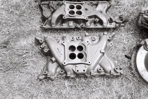 1973 Ford Ranchero - Two engine intake manifolds are shown resting on a grassy surface, with a watermark visible in the lower right corner.