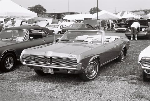 1973 Ford Ranchero - A silver convertible with a distinctive grille is parked on grass at an outdoor event.