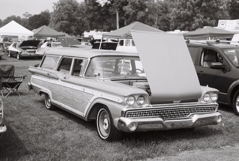 1973 Ford Ranchero - Wood-paneled station wagon with hood up at an outdoor event, other vehicles visible.