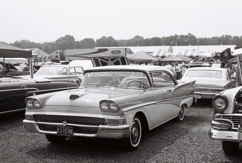 1973 Ford Ranchero - A classic two-tone 1957 Ford Fairlane 500 is displayed at an outdoor car show with tents and other vehicles in the background.
