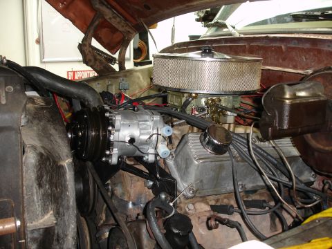 1977 Ford F-150 - Aftermarket AC compressor installation in a V8 engine bay, with air filter and carburetor visible.