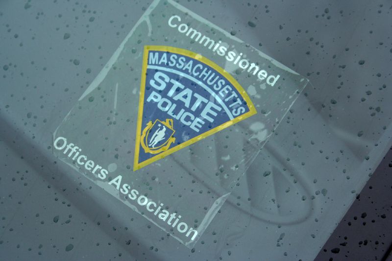 Massachusetts State Police sticker on a car window. Text reads 'Commissioned Officers Association'