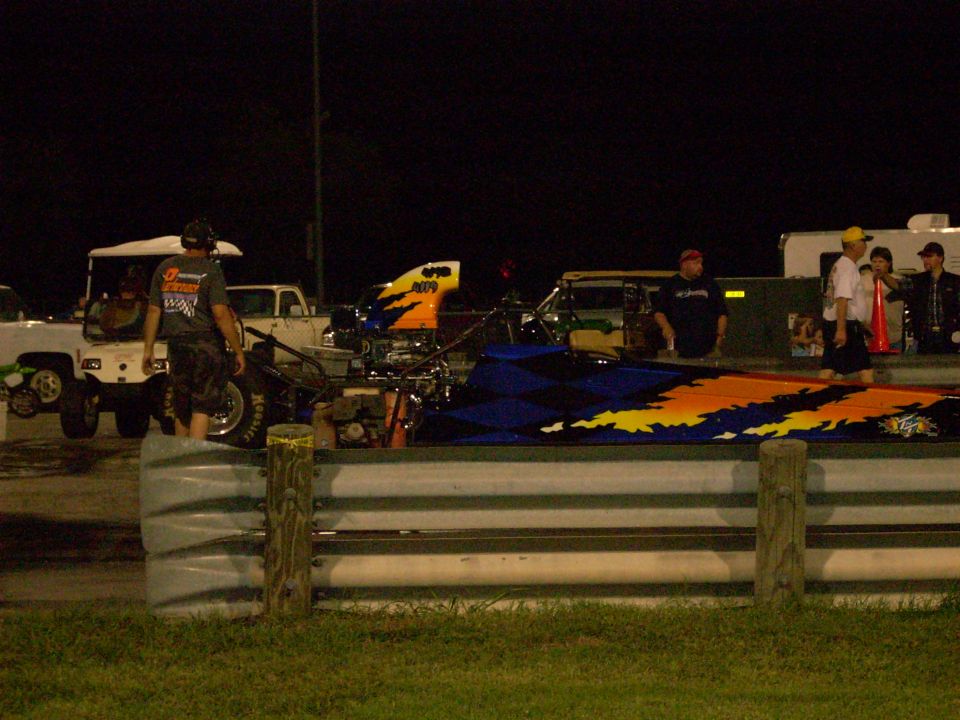 Dragster with flame graphics on a track at night