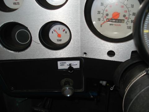 1979 Chevrolet C/K Pickup - Close-up of a vehicle's dashboard gauges and controls, including a speedometer and temperature gauge.