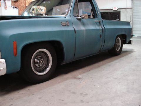1979 Chevrolet C/K Pickup - Side view of a teal 1979 Chevrolet C/K Pickup truck with custom wheels and lowered stance.