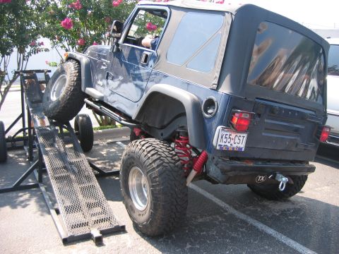 2001 Jeep Wrangler - A blue Jeep Wrangler is positioned on a metal ramp, showing its rear and side profile with modifications.