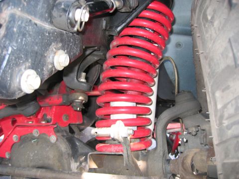 2001 Jeep Wrangler - Close-up view of a red coil spring and associated suspension parts.