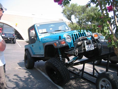 2001 Jeep Wrangler - A bright blue 2001 Jeep Wrangler is positioned on a trailer, equipped with a winch and off-road tires.