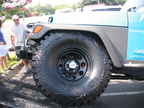 2001 Jeep Wrangler - A blue Jeep Wrangler is shown from the front quarter angle, focusing on the front tire and fender area.