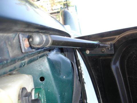 1993 Ford Taurus - Close-up view of a car's hood strut and surrounding components.