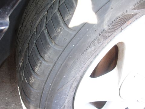 1991 Ford Taurus - This image shows a close-up of a tire, focusing on its tread and sidewall markings.