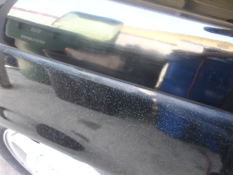 1991 Ford Taurus - Close-up of a black car door showing imperfections and reflections.