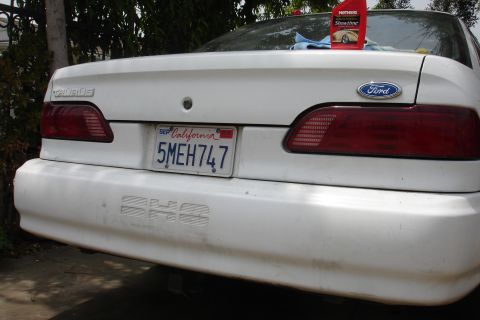 1992 Ford Taurus - Rear view of a 1992 Ford Taurus, showing taillights, license plate, and a bottle of car wax.
