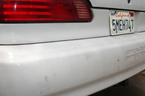 1992 Ford Taurus - Rear view of a white 1992 Ford Taurus, showing the bumper and taillight.