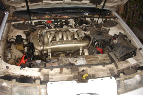 1992 Ford Taurus - The engine bay of a 1992 Ford Taurus shows the V6 engine, air intake, and various hoses and wires.