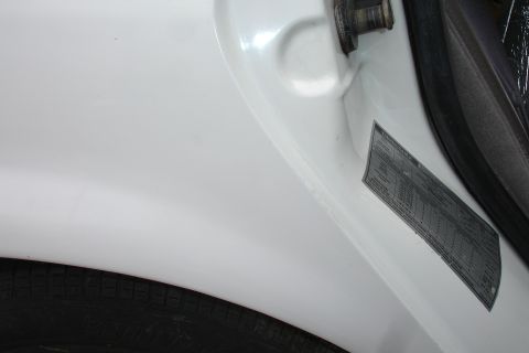 1992 Ford Taurus - Close-up of a vehicle's door jamb, showing a tire and a VIN sticker.