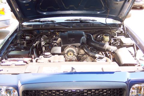 2001 Ford Crown Victoria - The engine compartment of a blue vehicle is open, showing various engine components.