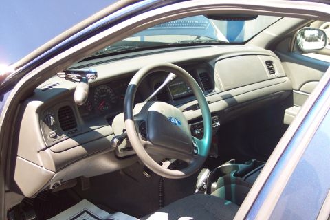 2001 Ford Crown Victoria - The interior of a 2001 Ford Crown Victoria police car, the dashboard, steering wheel, and center console.