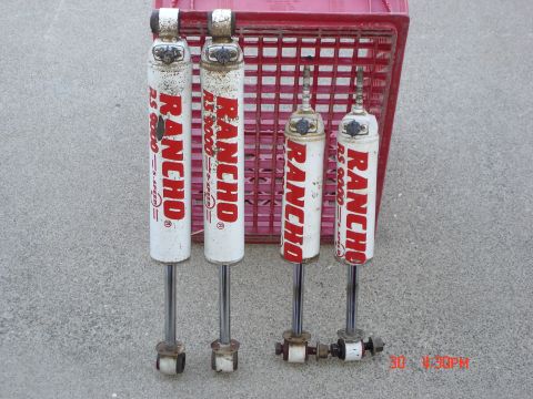 1996 Ford Bronco - Four Rancho RS 5000 shock absorbers are displayed, two longer and two shorter, against a red crate.