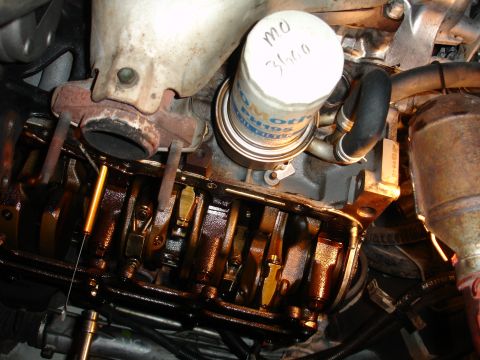 1992 Ford Taurus - Close-up view of an engine's internal components, including the crankshaft and oil pan, during maintenance.