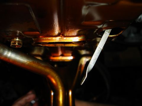 1992 Ford Taurus - Close-up of an engine oil dipstick, indicating the oil level within the engine.